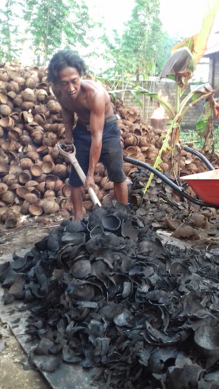 Worker handling charcoal at carbonization site