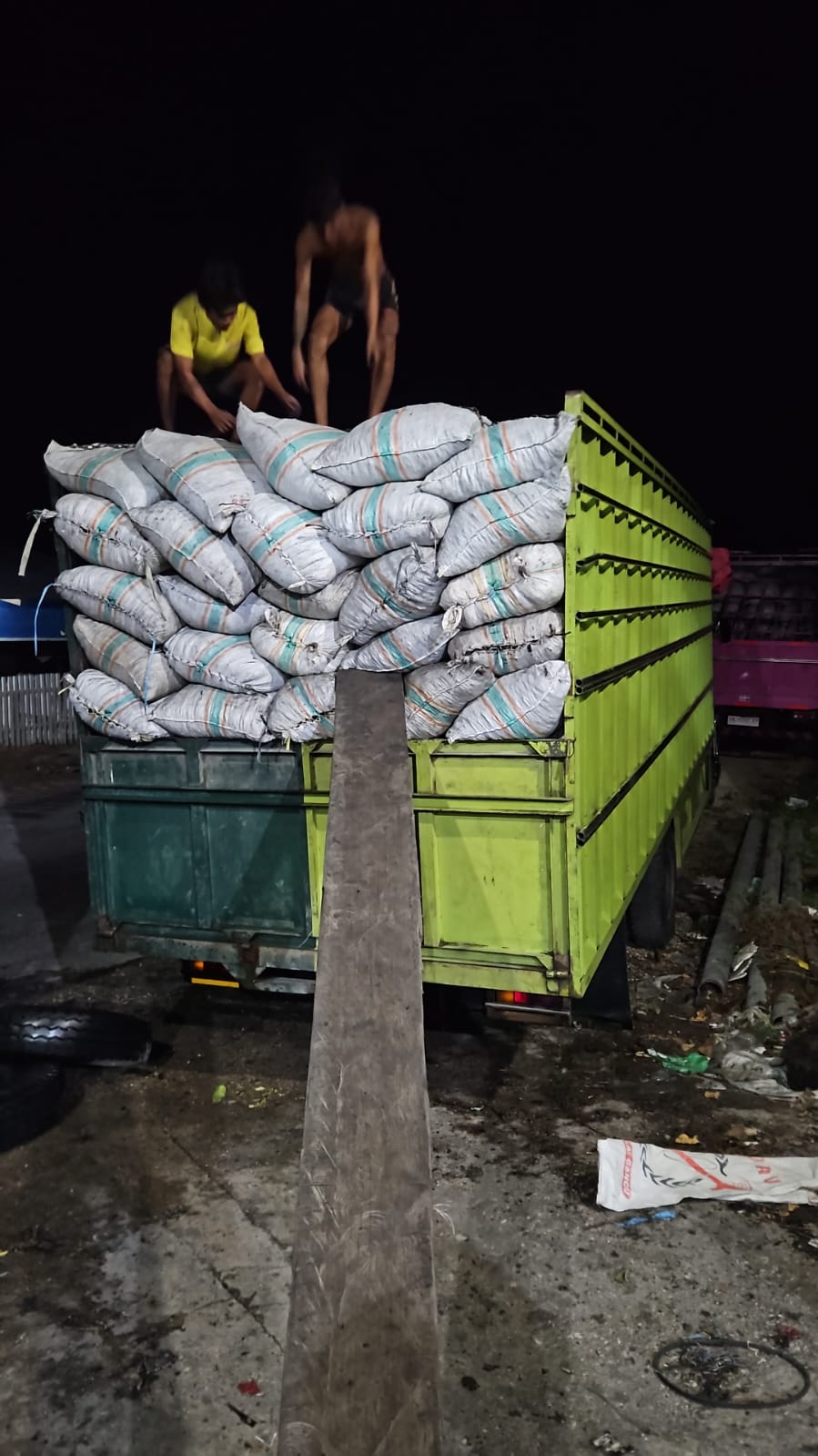 Truck loaded with woven sacks at night with loading ramp